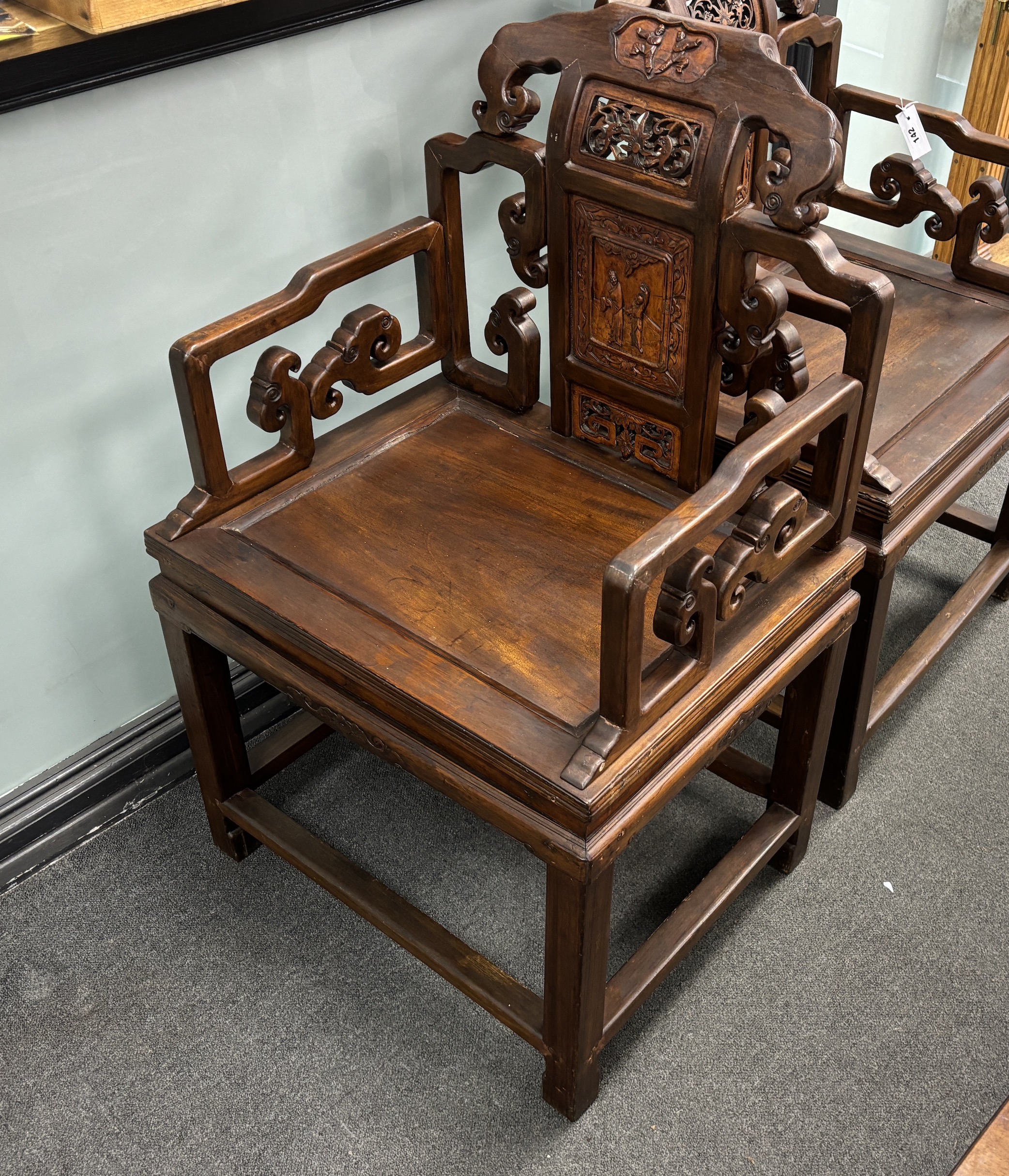 A pair of Chinese carved hardwood elbow chairs width 65cm, depth 52cm, height 103cm.